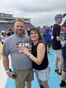 Two RaceAway guests pose on the track apron at Phoenix Raceway during pre-race activities for the 2026 Freeway Insurance 500.