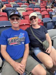 Two RaceAway guests smile from their seats in the grandstands at Phoenix Raceway before the 2026 Freeway Insurance 500.