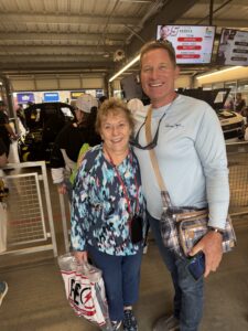Two RaceAway guests smile inside the NASCAR Cup Series garage at Phoenix Raceway during the 2026 Freeway Insurance 500 weekend.